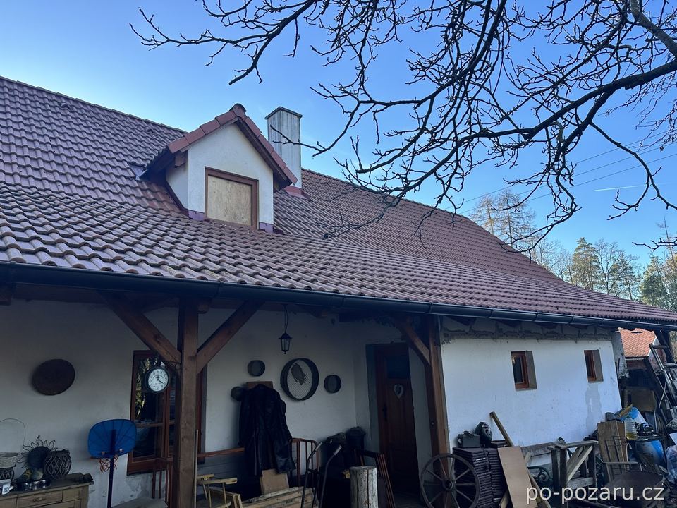 Zděný dům s krovem po požáru, zakrytý vikýř a obnažený věnec pod okapem.